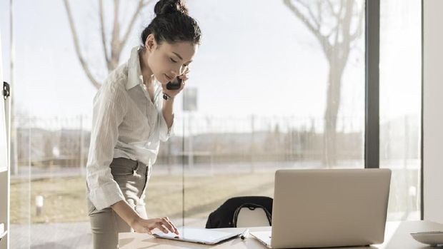 Asian businesswoman on the phone and using digital tablet