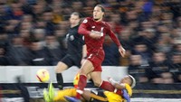 Virgil van Dijk membuat pemain Wolves kerepotan. Meski sempat kalah langkah dalam mengejar bola, Van Dijk pada akhirnya bisa memenangi perebutan bola. (Foto: Darren Staples/Reuters)