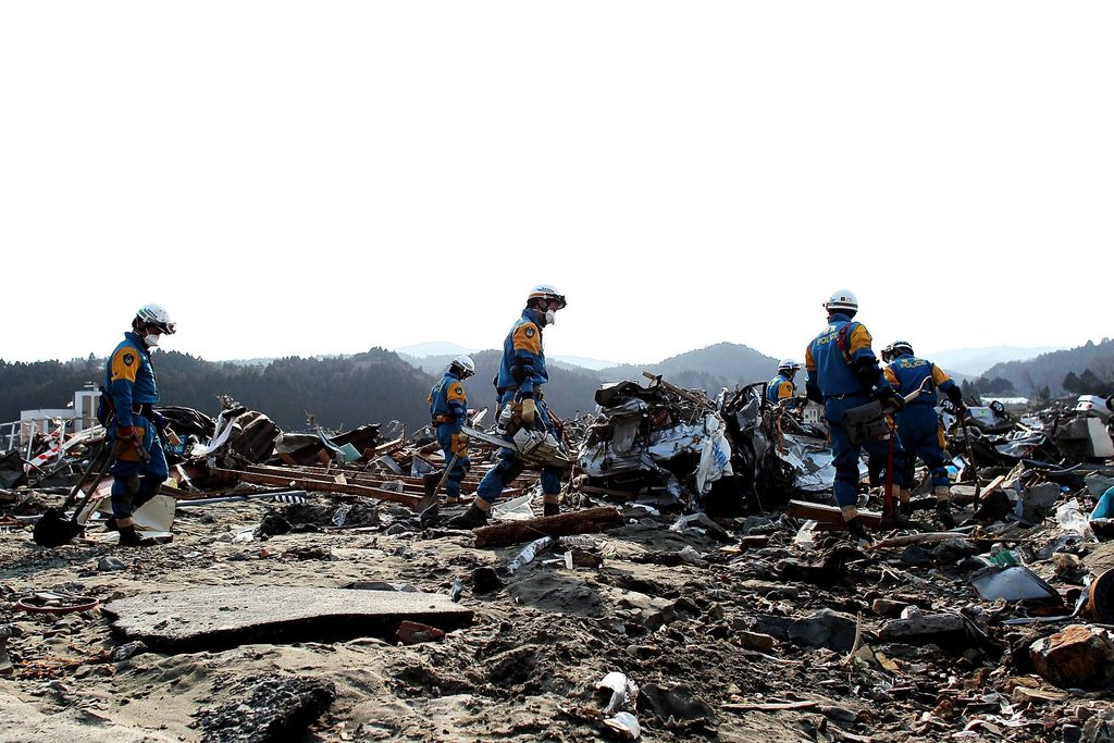 MINAMISANRIKU, JAPAN - MARCH 19: Police search and rescue crews search through rubble on March 19, 2011 in Minamisanriku, Japan. Many people have begun to return to their homes as the search continues for thousands still missing after a 9.0 magnitude strong earthquake struck on March 11 off the coast of north-eastern Japan. The quake triggered a tsunami wave of up to 10 metres which engulfed large parts of north-eastern Japan. The current death toll stands at 7,197.  (Photo by Chris McGrath/Getty Images)