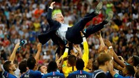 Orang di balik sukses Prancis menjuarai Piala Dunia 2018. Pelatih Didier Deschamps dilambungkan ke udara oleh para pemainnya sebagai tanda terima kasih. Ini adalah trofi Piala Dunia kedua bagi Deschamps, yang sebelumnya memenanginya saat masih aktif bermain pada 1998. Foto: Kai Pfaffenbach/Reuters