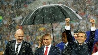 Kegembiraan Presiden Prancis Emmanuel Macron [kanan] saat negaranya memenanangi Piala Dunia 2018. Macron bahkan tak menghiraukan hujan deras. Di sebelah Macron, berdiri Presiden Rusia Vladimir Putin dan Presiden FIFA Gianni Infantino. Foto: Kai Pfaffenbach/Reuters