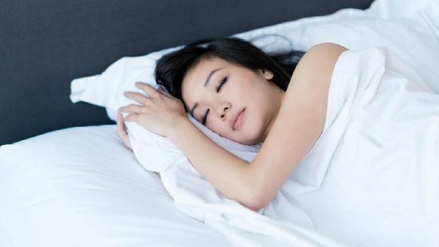 Asian woman sleeping in bed at home and looking very peaceful - lifestyle concepts