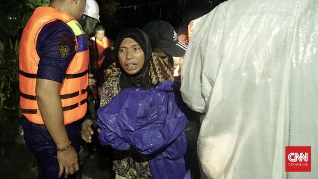 Tim gabungan mengevakuasi warga di BTN Sentul, Labuan, Banten, yang rumahnya terendam banjir, Senin (31/12).