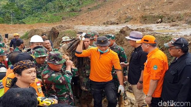 Petugas mengevakuasi mayat tertimbun longsor di kampung adat Sukabumi.