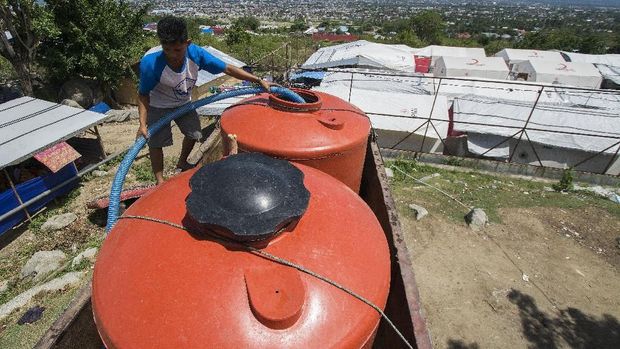 Pekerja bersiap menyalurkan air bersih ke tandon pengungsi di Kamp Terpadu Kelurahan Balaroa, Palu, Sulawesi Tengah, Kamis (3/1/2019). Setelah memasuki masa perpanjangan transisi darurat atau tiga bulan pascabencana, pengungsi mulai merasakan kesulitan air bersih karena suplai dari para relawan semakin berkurang dan sementara itu tidak ada sumber air di kamp tersebut. ANTARA FOTO/Basri Marzuki/foc.