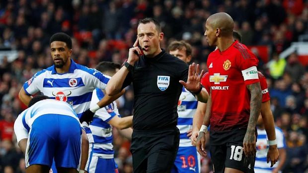 Stuart Attwell berkomunikasi dengan asisten wasit sebelum memberikan penalti untuk Man United.