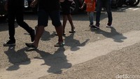Para suporter melangkahkan kakinya menuju lapangan usai memarkir kendaraannya.
