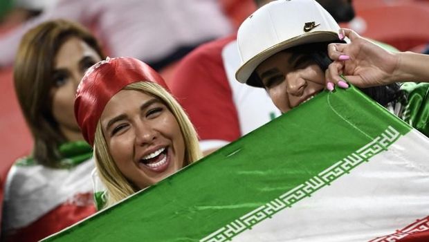Suporter wanita Iran membentangkan bendera saat menyaksikan Iran vs Yaman di Piala Asia 2019.