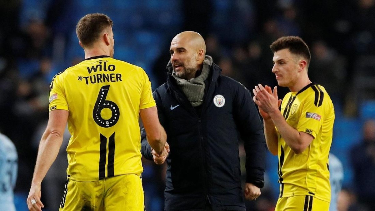 Pep Guardiola menyalami para pemain Burton Albion di akhir laga leg pertama semifinal Piala Liga Inggris (Phil Noble/Reuters)