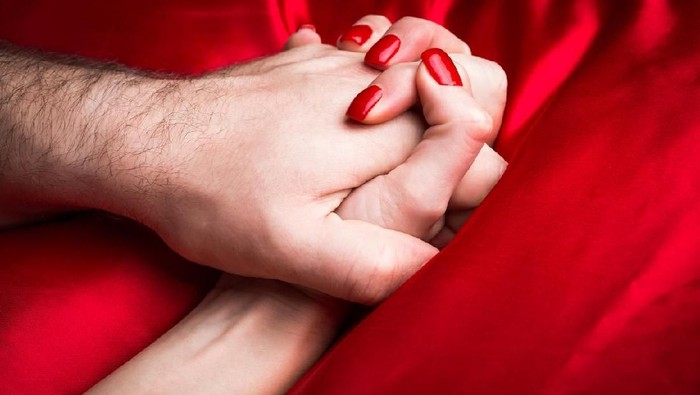 orgasme seks pasutri Young female holding hands sensually on red silk bed.