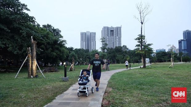Warga menikmati akhir pekan di Hutan kota  Gelora Bung Karno, Jakarta, 12 Januari 2019. Hutan kota di kawasan GBK tersebut dilengkapi dengan jogging track yang membuat penggunanya dapat berolahraga sekaligus menikmati pemandangan pepohonan serta kolam ikan yang dikeliling gedung pencakar langit. ( CNN Indonesia/ Hesti Rika)