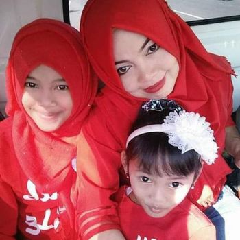 Potret Alm. Lili dan dua puterinya dengan busana serba merah.