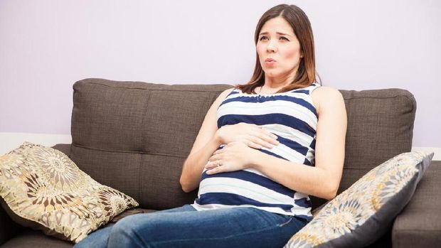 Portrait of a young pregnant woman focusing on her breathing while she has braxton hicks contractions