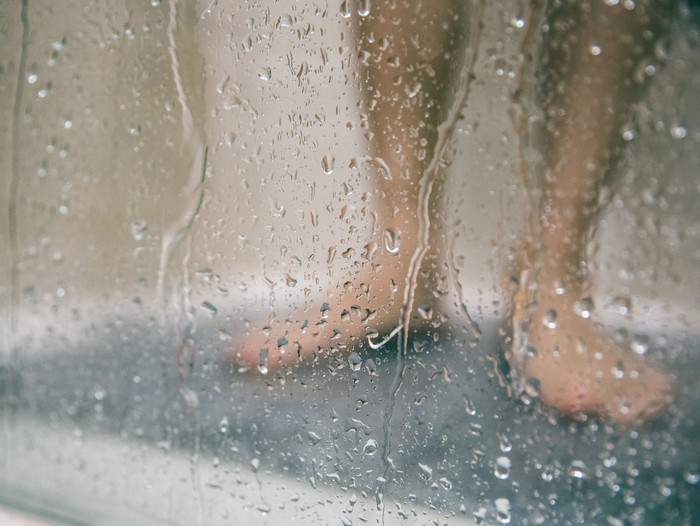 back view of attractive african american woman with sponge taking shower mandi pagi