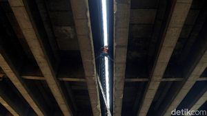 Pekerja Ini Bergelantungan untuk Perbaiki Saluran Air Tol Wiyoto Wiyono