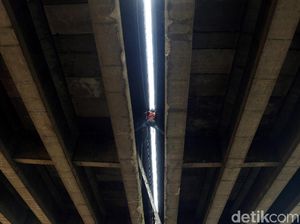 Pekerja Ini Bergelantungan untuk Perbaiki Saluran Air Tol Wiyoto Wiyono