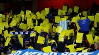 Sejumlah suporter mengangkat poster kuning sebagai bentuk penghormatan kepada Emiliano Sala sebelum pertadingan dimulai. Eddie Keogh/Reuters.