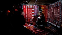 Para pedagang kaki lima di sekitaran Anfield biasanya berjualan jelang pertandingan kandang Liverpool. Anda tertarik membeli pernak-pernik tersebut? (Carl Recine/Reuters)