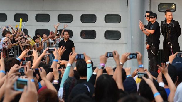 TO GO WITH Entertainment-Malaysia-SKorea-music-Kpop,FOCUS by Julia ZappeiIn this photograph taken on January 16, 2013, South Korean K-pop band Epik High (R) greet their fans on the red carpet on the final day of the 27th Golden Disk Awards at the Sepang International Circuit in Sepang outside Kuala Lumpur.  Organisers said the annual Golden Disk Awards, viewed as the Korean Grammys and which included occasionally racy performances by some of K-pop's biggest acts, saw more than 15,000 tickets sold for January 15-15. Malaysia became the second country outside South Korea to host the awards, as K-Pop's bubble-gum tunes and dance moves continue to defy language barriers and find fans around the world.      AFP PHOTO / MOHD RASFAN (Photo by MOHD RASFAN / AFP)