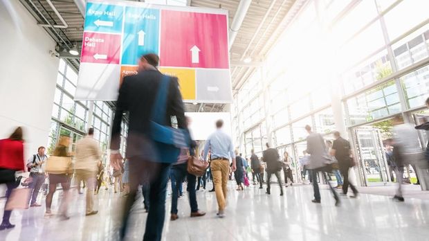 crowd of blurred business people rushing in a trade fair floor. ideal for websites and magazines layouts