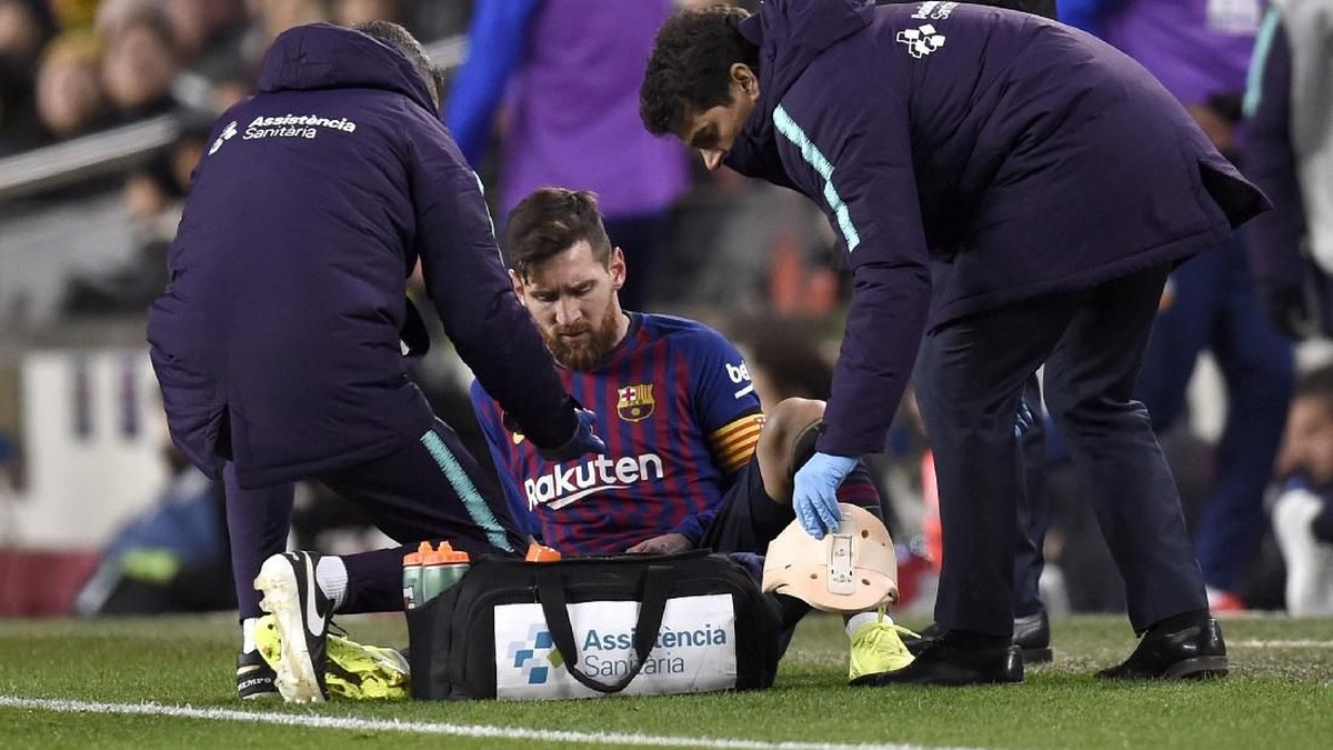 Lionel Messi saat mendapat perawatan tim medis di laga Barcelona vs Valencia. (Foto: Alex Caparros/Getty Images)