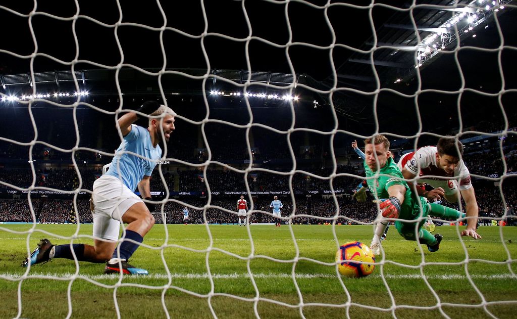 Soccer Football - Premier League - Manchester City v Arsenal - Etihad Stadium, Manchester, Britain - February 3, 2019  Manchester City's Sergio Aguero scores their third goal to complete his hat-trick as Arsenal's Laurent Koscielny and Bernd Leno look on  REUTERS/Andrew Yates    EDITORIAL USE ONLY. No use with unauthorized audio, video, data, fixture lists, club/league logos or 