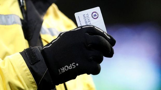 Petugas keamanan di Etihad memegang tiket away Chelsea yang dibuang suporternya.