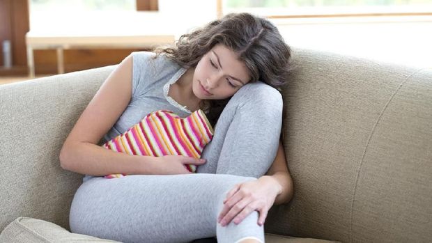 Sad lonely woman lying in the bed in fetal position