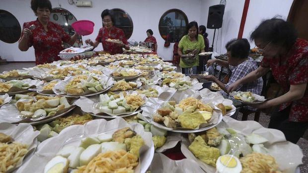 Warga Tionghoa menyiapkan lontong beserta lauk pauknya ke dalam piring di Kelenteng Tjoe Hwie Kiong di Kota Kediri, Jawa Timur, Selasa (19/2/2019). Sebanyak 1.100 lontong disajikan untuk dimakan bersama saat merayakan Cap Go Meh sebagai rangkaian penutupan perayaan Tahun Baru Imlek. ANTARA FOTO/Prasetia Fauzani/wsj.