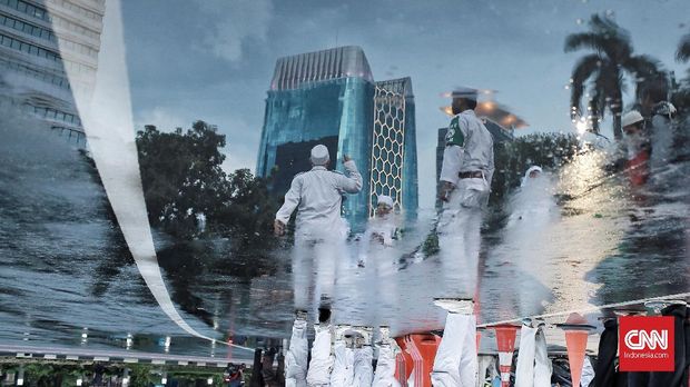 Sejumlah ornag berseragam putih-putih mengawal gelaran Munajat 212.