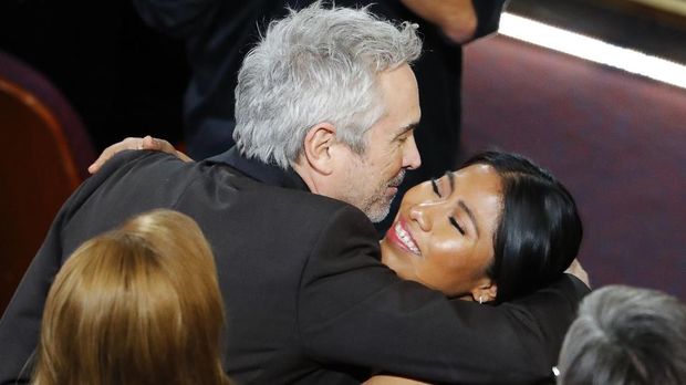 Alfonso Cuaron (kiri) memeluk Yalitza Aparicio, bintang 'Roma' (kanan), saat film itu memenangkan Best Director.