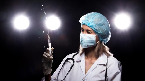 Asian Beautiful Doctor Nurse woman in uniform with stethoscope, rubber gloves, mask check syringe injection, portrait , studio lighting dark background four back light flare silhouette copy space