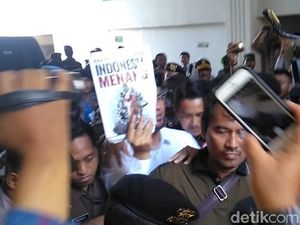 Sebelum Masuk Ruang Sidang, Dhani Acungkan Buku Indonesia Menang Sebelum Masuk Ruang Sidang, Dhani Acungkan Buku Indonesia Menang