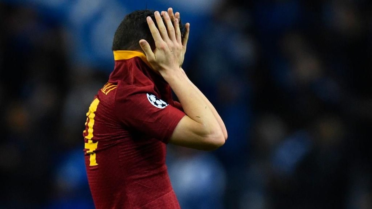 Pemain AS Roma Alessandro Florenzi menutupi wajahnya usai kalah 1-3 dari FC Porto di leg kedua babak 16 besar Liga Champions di Estadio Do Dragao, Kamis (7/3/2019) dini hari WIB. Roma gagal ke perempatfinal. (Foto: Octavio Passos/Getty Images)