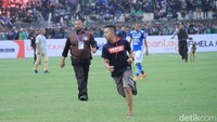 Sejumlah pendukung Persib meloncat dari atas tribune ke tengah stadion untuk mengejar para pemain Persib.