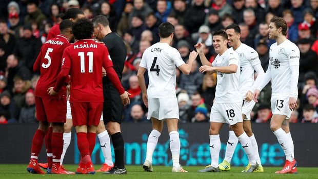 Skuat Burnley berselebrasi ucai cetak gol, sementara pemain Liverpool melakukan protes.