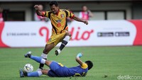 Pemain belakang Bhayangkara FC melakukan takel bersih kepada penyerang Mitra Kukar.