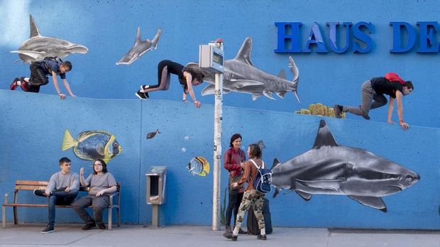 People practice city parkour as others wait for a bus near the Haus Des Meeres aquarium in Vienna, Austria on April 13, 2018. (Photo by JOE KLAMAR / AFP)