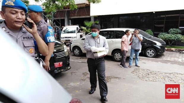 Pihak yang diduga penyidik KPK dan sejumlah petugas kepolisian di dekat ruang pemeriksaan terhadap Romi.