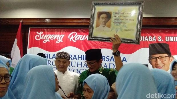 Sandiaga Uno memperlihatkan isi bingkisan dari keluarga KH Ahmad Dahlan. 