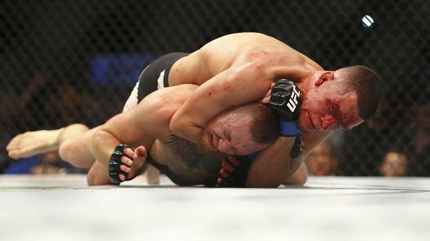 Perjalanan Karier Conor McGregor di UFC LAS VEGAS, NV - MARCH 5: Nate Diaz applies a choke hold to win by submission against Conor McGregor during UFC 196 at the MGM Grand Garden Arena on March 5, 2016 in Las Vegas, Nevada. Rey Del Rio/Getty Images/AFP