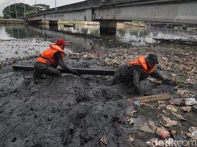 Aksi Petugas UPK Badan Air Mandi Lumpur Bersihkan Sampah