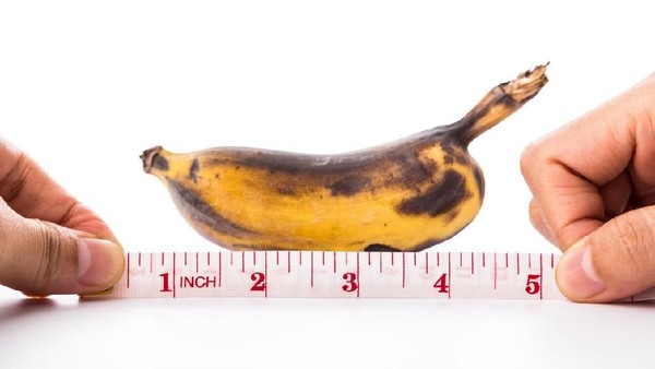 banana and measuring tape on white background