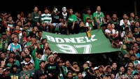 Mereka mulai aksinya dengan mengenakan baju hijau, syal, topi hingga mengibarkan bendera lengkap dan tak ketinggalan spanduk-spanduk berisi kalimat dukungan untuk Persebaya.