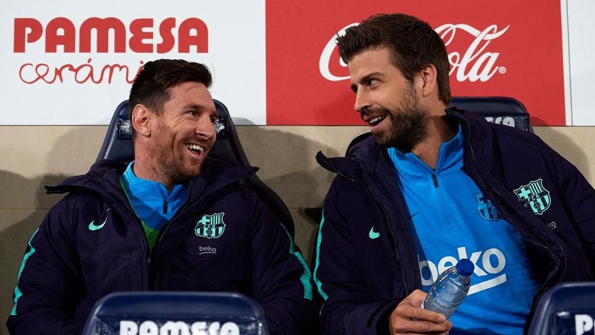 Lionel Messi dan Gerard Pique (kanan) di bench pemain Barcelona saat menghadapi Villarreal. (Foto: Manuel Queimadelos Alonso/Getty Images)
