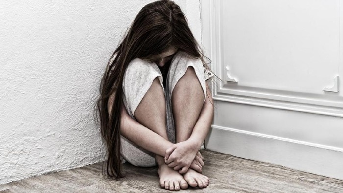 Teenage girl sitting on a staircase outside feeling depressed