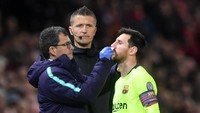 Messi mendapat perawatan dari tim medis Barcelona di pinggir lapangan Old Trafford. (Foto: Michael Regan/Getty Images)