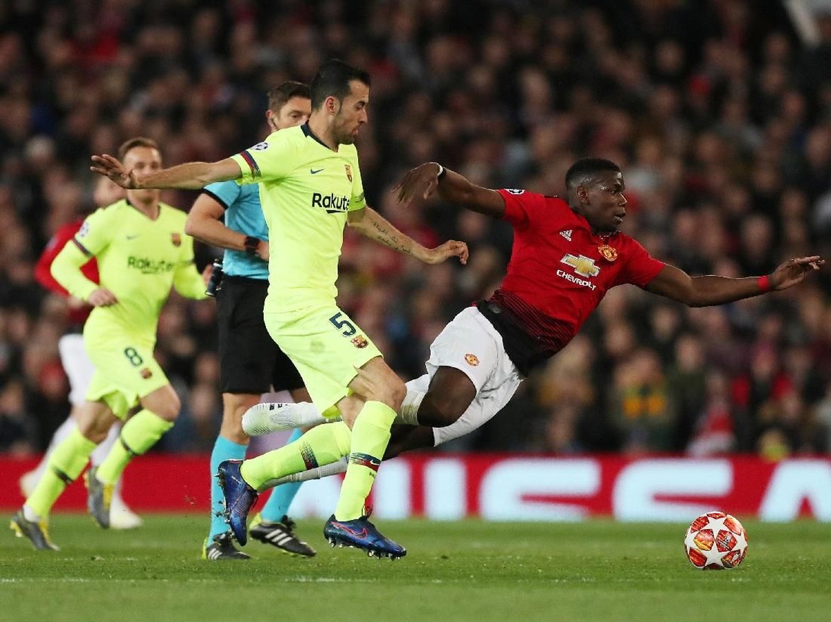 Pemain Barcelona, Sergio Busquets, saat mengadang Paul Pogba di kandang Manchester United. (Foto: Lee Smith/Actions Images via Reuters)