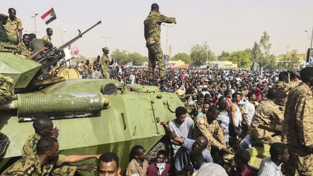 Lingkaran Setan Kudeta di Sudan Sudanese soldiers stand guard on armoured military vehicles as demonstrators continue their protest against the regime near the army headquarters in the Sudanese capital Khartoum on April 11, 2019. - The Sudanese army is planning to make