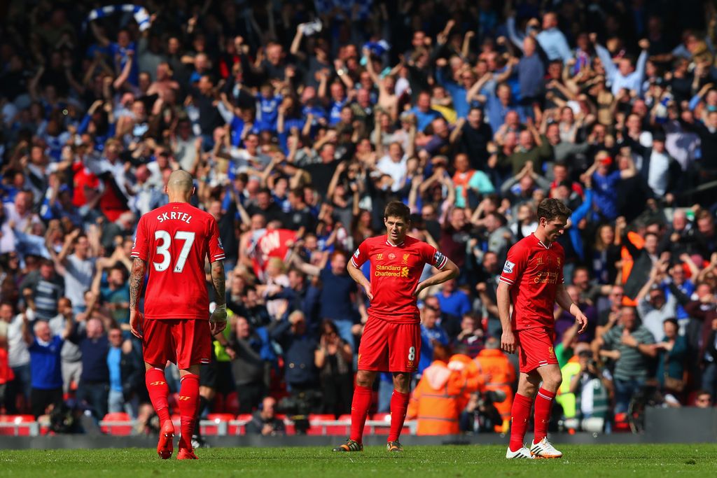 LIVERPOOL, ENGLAND - APRIL 27:  A dejected  Martin Skrtel, Steven Gerrard and Joe Allen of Liverpool look on as the Chelsea fans celebrate after Willian of Chelsea scored their second goal during the Barclays Premier League match between Liverpool and Chelsea at Anfield on April 27, 2014 in Liverpool, England.  (Photo by Clive Brunskill/Getty Images)
